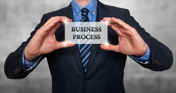 Homme d'affaires tient carte blanche avec le signe de processus d'affaires. Isolé sur différents milieux - Photo de stock — Photo