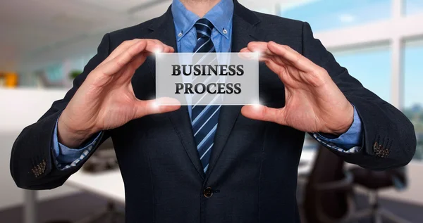Homme d'affaires tient carte blanche avec le signe de processus d'affaires. Isolé sur différents milieux - Photo de stock — Photo