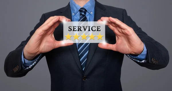 Hombre de negocios sosteniendo la tarjeta blanca con el signo de Servicio Cinco Estrellas. Aislado en varios fondos- Foto de Stock —  Fotos de Stock