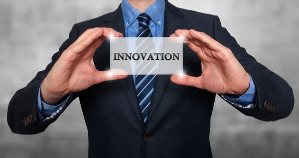 Businessman holding white card with Innovation sign - Stock Photo — Stock fotografie