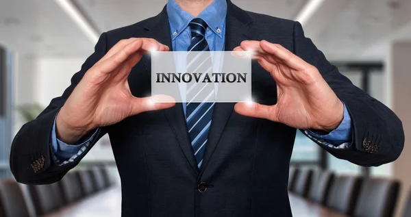 Empresario sosteniendo tarjeta blanca con signo de innovación - Stock Photo —  Fotos de Stock