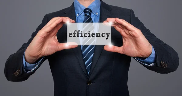 Businessman holds efficiency sing in his hands - Stock Image — Stock Photo, Image