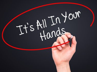 Man Hand writing It's All In Your Hands  with black marker on vi