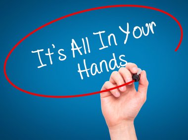 Man Hand writing It's All In Your Hands  with black marker on vi