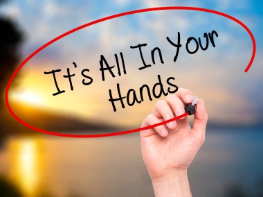 Man Hand writing It's All In Your Hands  with black marker on vi
