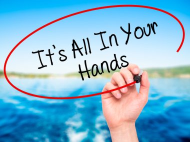 Man Hand writing It's All In Your Hands  with black marker on vi