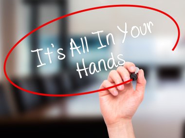 Man Hand writing It's All In Your Hands  with black marker on vi