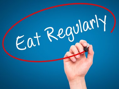 Adam el düzenli olarak yemek ile siyah kalemi görsel dağ eteğindeki taş yığını üzerinde yazma