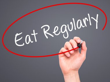 Adam el düzenli olarak yemek ile siyah kalemi görsel dağ eteğindeki taş yığını üzerinde yazma