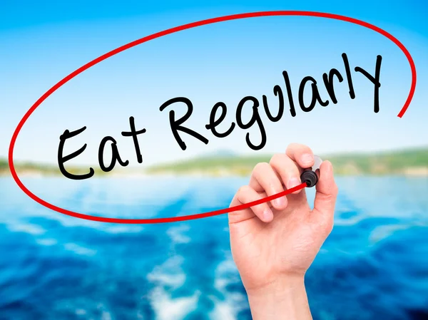 Man Hand writing Eat Regularly with black marker on visual scree — Stock Photo, Image