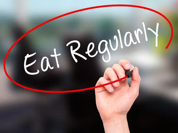 Man Hand writing Eat Regularly with black marker on visual scree — Stock Photo, Image