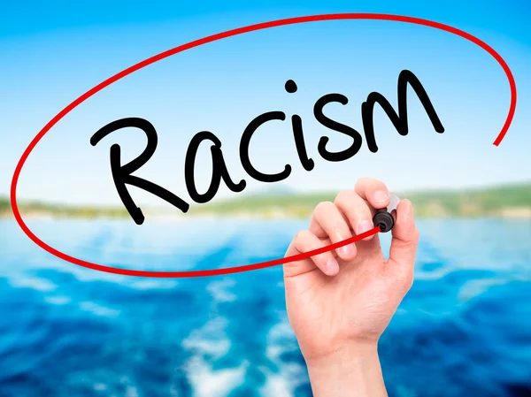 Man Hand writing Racism with black marker on visual screen. — Stock Photo, Image