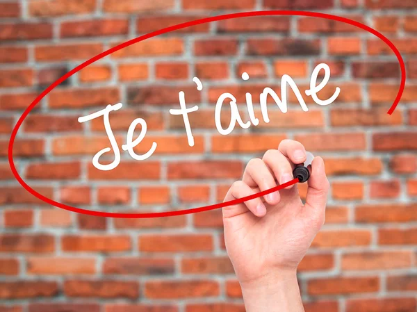 Man Hand writing Je t 'aime (I Love You in French) with black m — стоковое фото