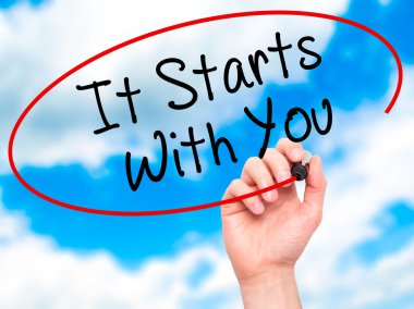 Man Hand writing It Starts With You with black marker on visual 