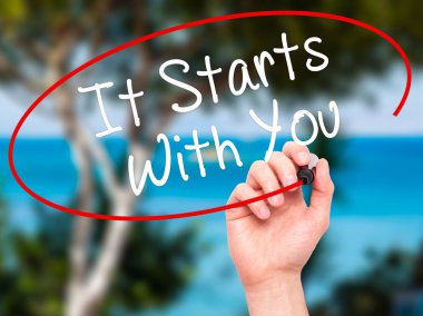 Man Hand writing It Starts With You with black marker on visual 