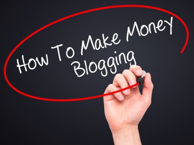 Man Hand writing How To Make Money Blogging with black marker on