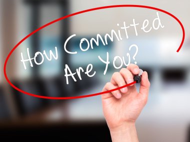 Man Hand writing How Committed Are You? with black marker on vis