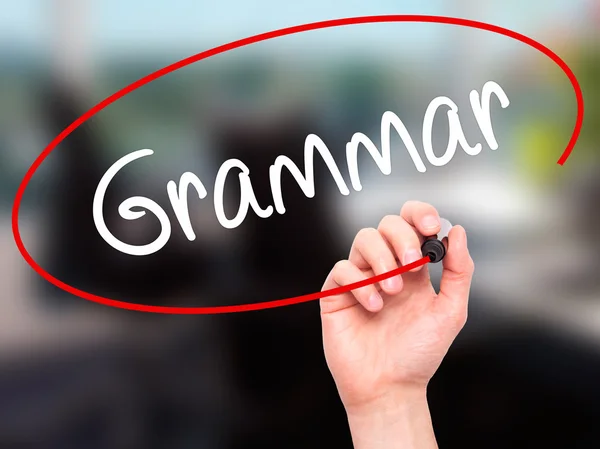 Man Hand skriver grammatik med svart markering på visuella skärm — Stockfoto