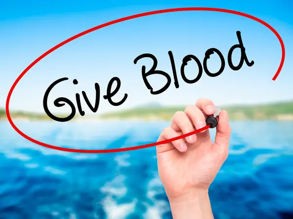 Muž ruční psaní darovat krev s černou značku na vizuální displej — Stock fotografie