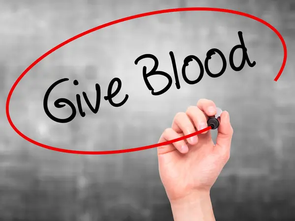 Рука человека пишет "Дайте кровь с черным маркером" на экране — стоковое фото