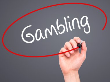 Man Hand writing Gambling  with black marker on visual screen
