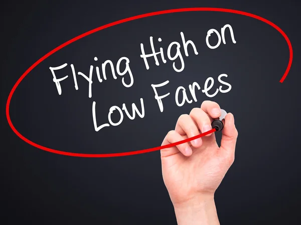 Man Hand writing Flying High on Low Fares with black marker on v