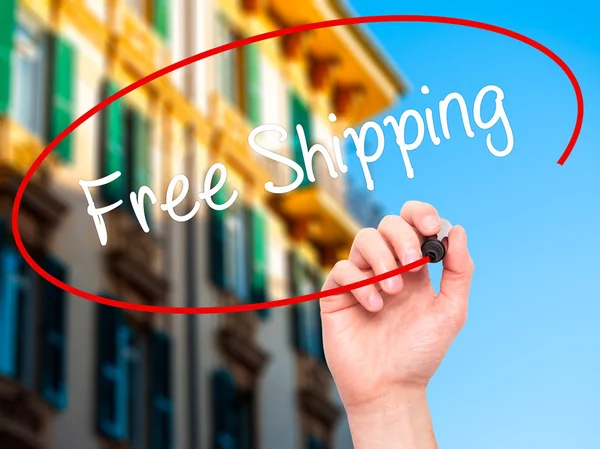 Man Hand writing Free Shipping with black marker on visual scree — Stock Photo, Image