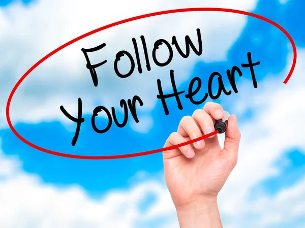 Ruka muže psaní Follow Your Heart černým fixem na vizuální s — Stock fotografie
