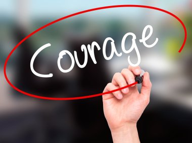 Man Hand writing Courage with black marker on visual screen