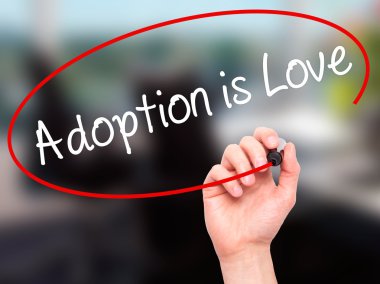 Man Hand writing Adoption is Love with black marker on visual sc clipart