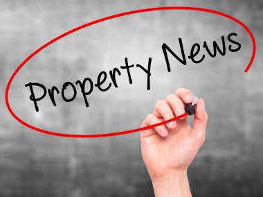 Adam el Emlak Haberleri ile siyah kalemi görsel dağ eteğindeki taş yığını üzerinde yazma.