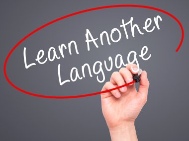 Man Hand writing Learn Another Language with black marker on vis