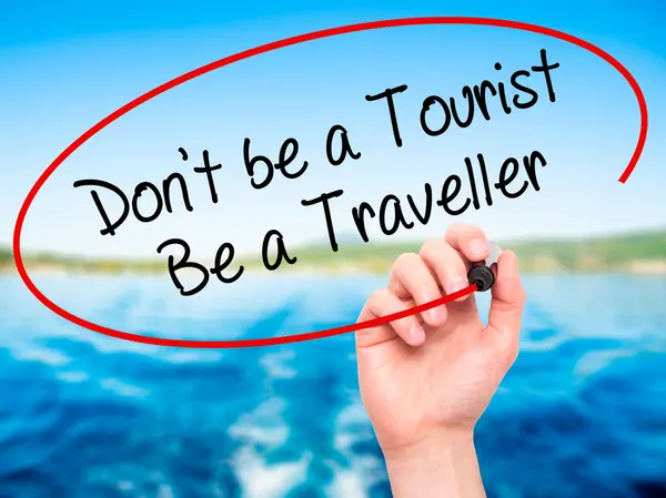 Man Hand writing Don 't be a Tourist Be a Traveller with black m — Foto de Stock