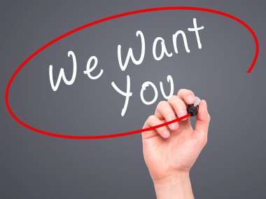 Man Hand writing We Want You with black marker on visual screen