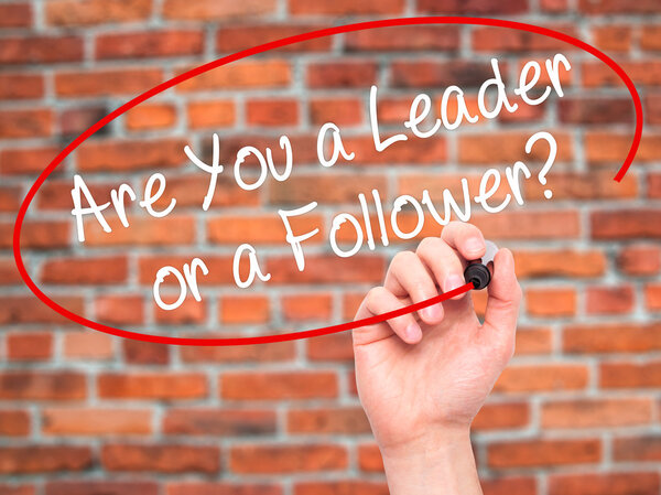 Man Hand writing Are You a Leader or a Follower? with black mark