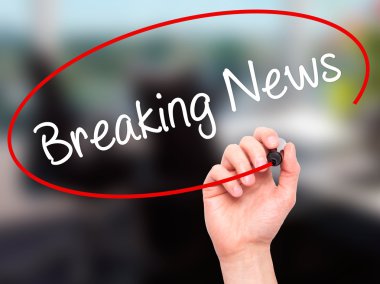 Adam el Breaking News siyah kalemi ile görsel dağ eteğindeki taş yığını üzerinde yazma.