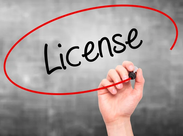 Man Hand writing License with black marker on visual screen