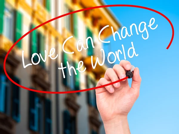 Человек, пишущий "Любовь может изменить мир" черным маркером — стоковое фото