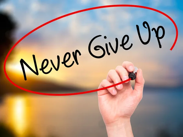 Man Hand writing Never Give Up con marcador negro en solapa visual — Foto de Stock