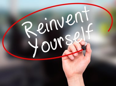 Man Hand writing Reinvent Yourself with black marker on visual s