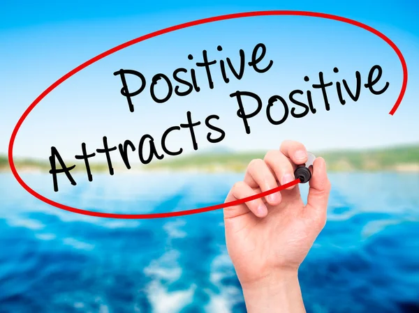 Man Hand writing Positive Attracts Positive with black marker on — Stock Photo, Image