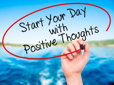 Man Hand writing Start your Dat with Positive Thoughts with blac