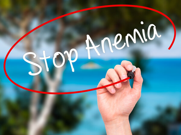 Человек рукой пишет остановить анемию с черным маркером на экране
