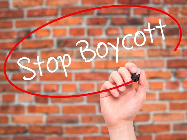 Человек рукой пишет Stop Boycott с черным маркером на визуальном экране — стоковое фото