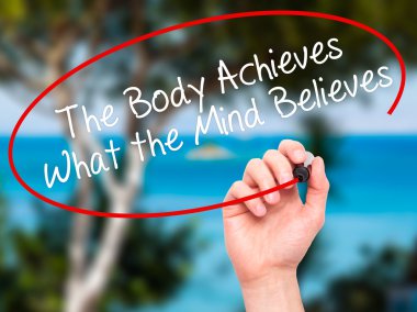 Man Hand writing The Body Achieves What the Mind Believes with b clipart