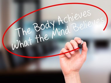 Man Hand writing The Body Achieves What the Mind Believes with b clipart