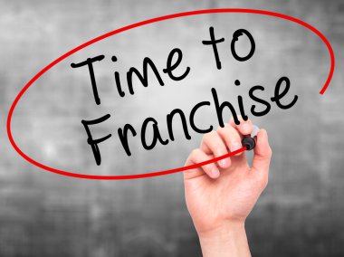 Man Hand writing Time to Franchise with black marker on visual s