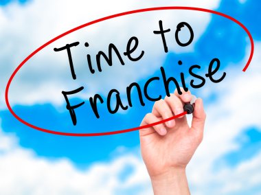 Man Hand writing Time to Franchise with black marker on visual s