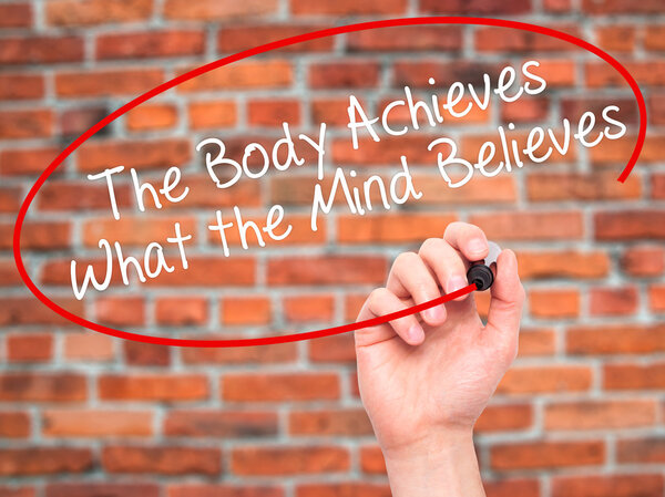 Man Hand writing The Body Achieves What the Mind Believes with b