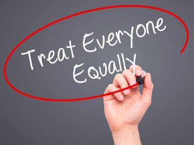 Man Hand writing Treat Everyone Equally with black marker on vis